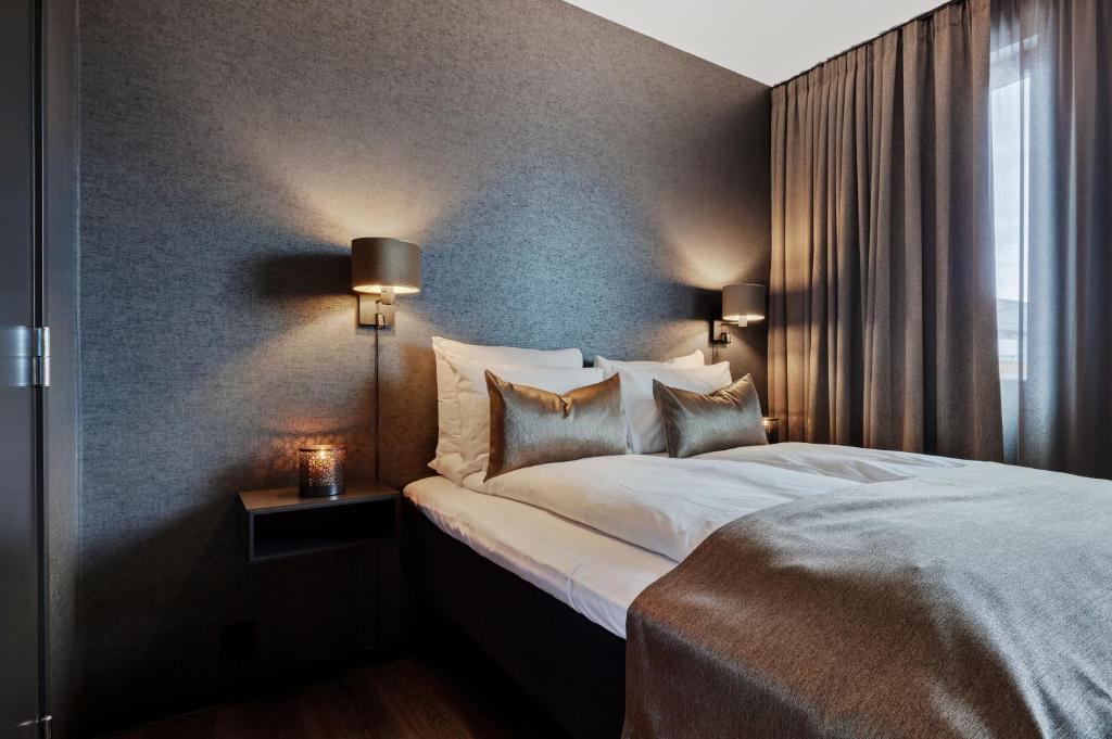 德拉门Origo Leilighetshotell- Øvre Storgate 5的一间卧室设有一张大床和一个窗户。