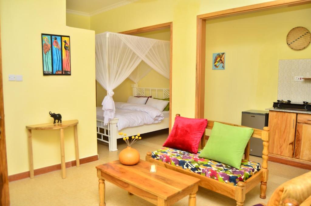 阿鲁沙Heart Of Africa Adventure and Apartments的客厅配有床和沙发