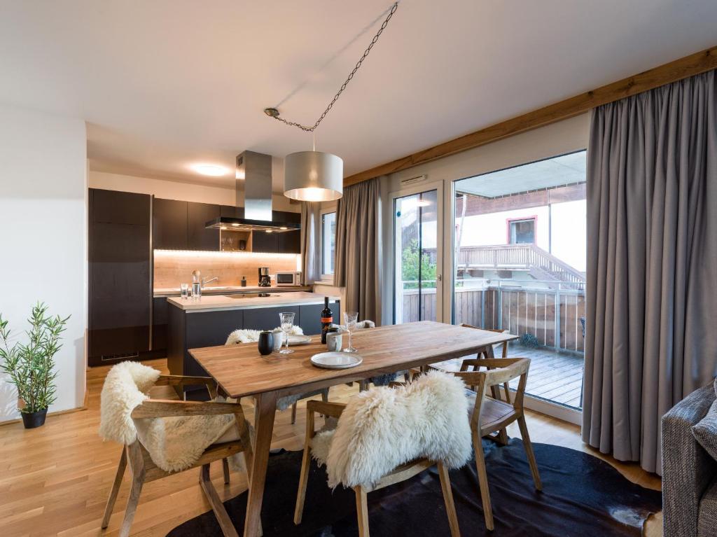 蒂罗尔-基希贝格Eastside by Apartment Managers的厨房以及带木桌和椅子的用餐室。