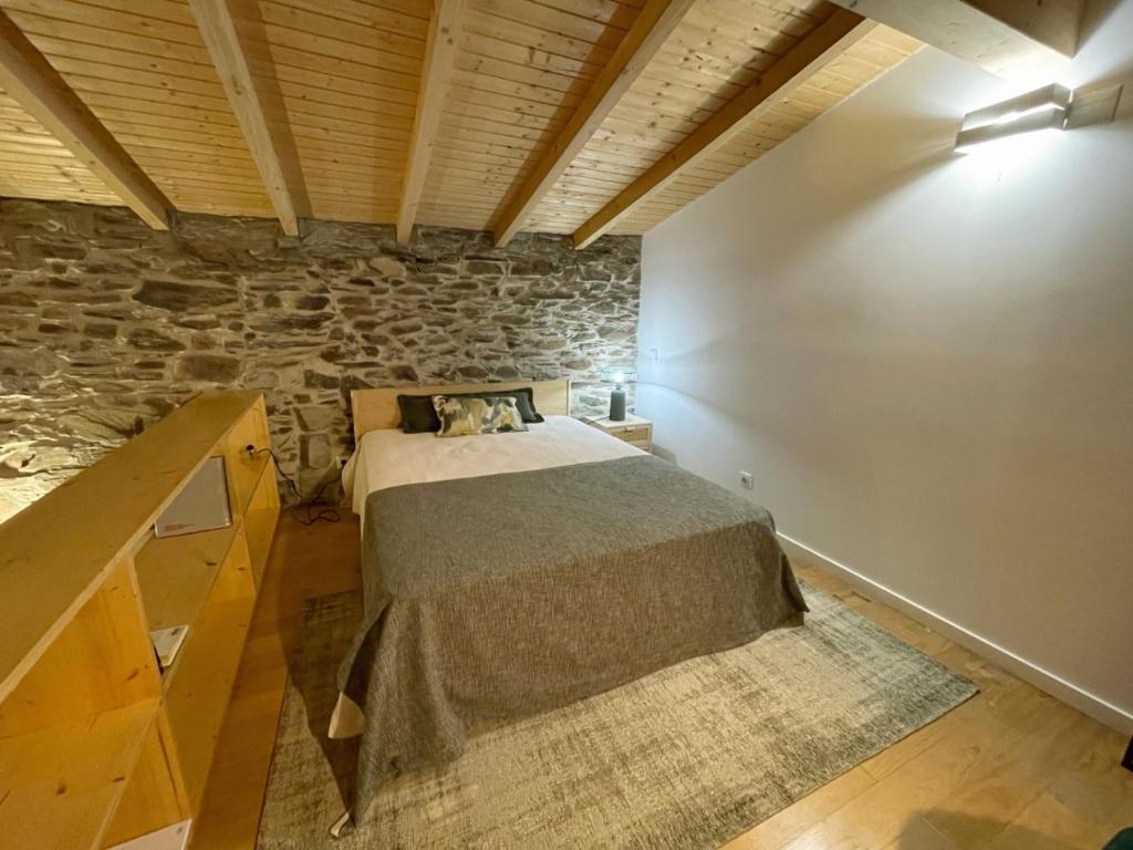 Sarzedasacalma - sesmo的一间卧室设有一张床和石墙