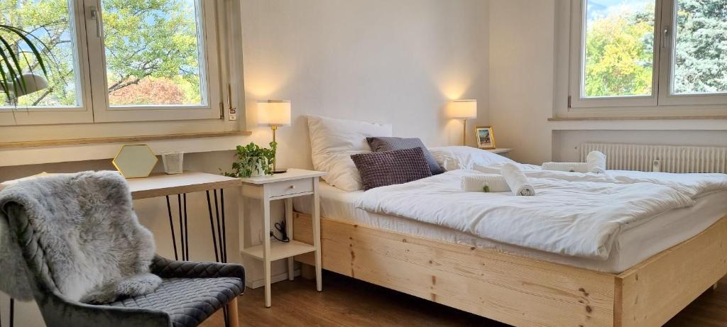梅拉诺Bergblick Apartment in Zentrumsnähe mit Garage的一间卧室配有一张带桌子和椅子的床