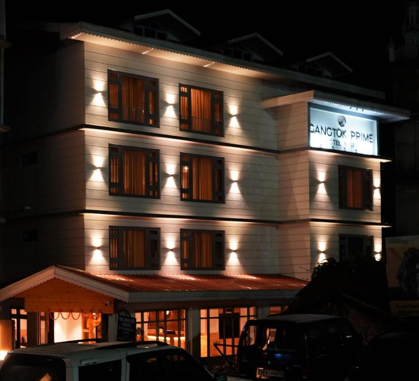 甘托克Gangtok Prime Hotel & Spa的白色的建筑,晚上有标志