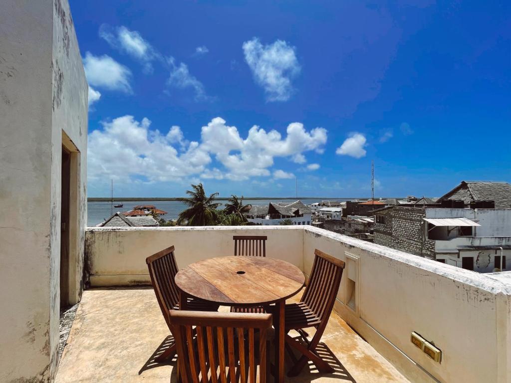 拉穆Lamu penthouse Apartment的海景阳台上的桌椅