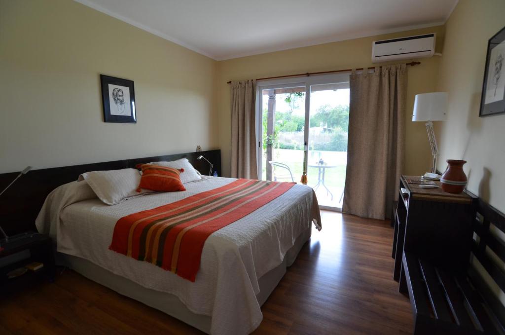El Encón查卡拉酒店的一间卧室设有一张床和一个滑动玻璃门