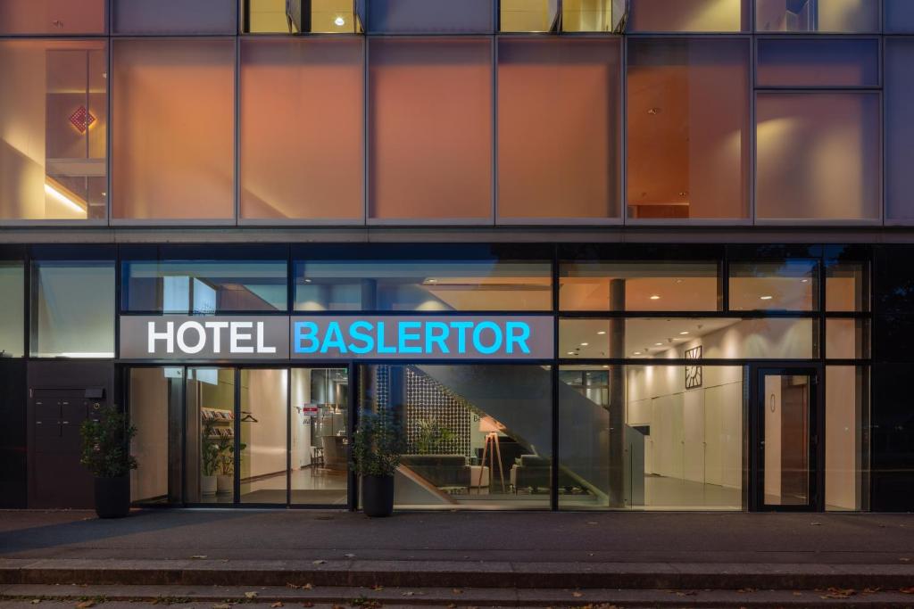 穆滕茨Hotel Baslertor的带有酒店后台的标志的酒店大楼