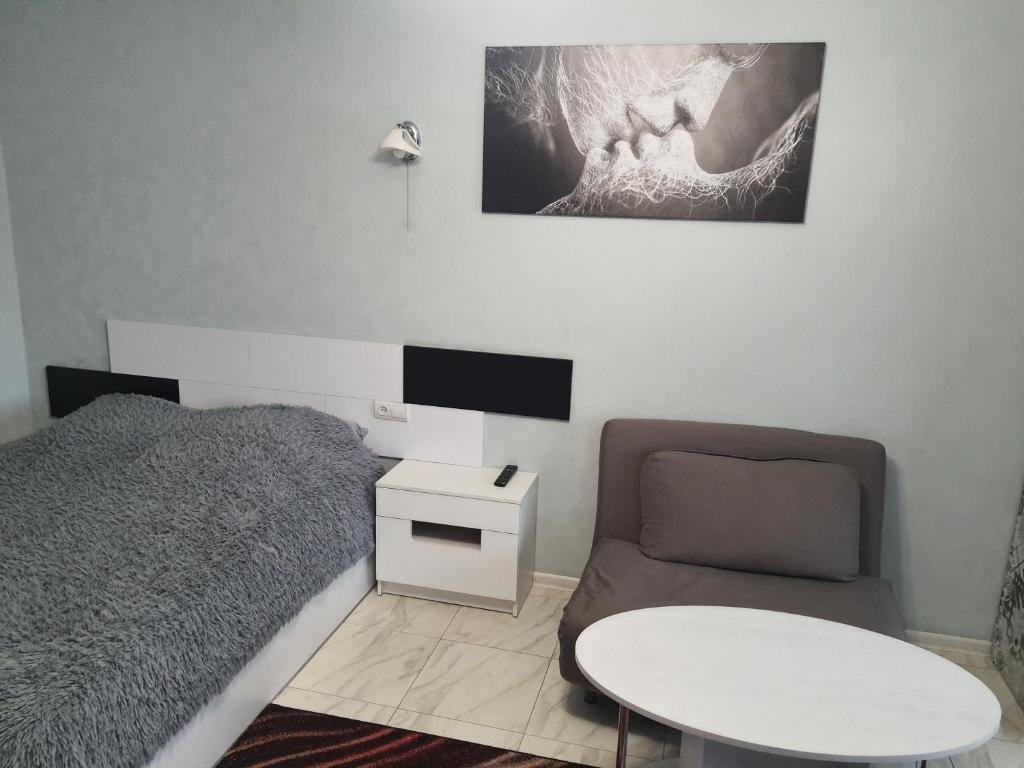 切尔尼戈夫Apartment on Mstyslavs'ka的一间卧室配有一张床、一把椅子和一张桌子