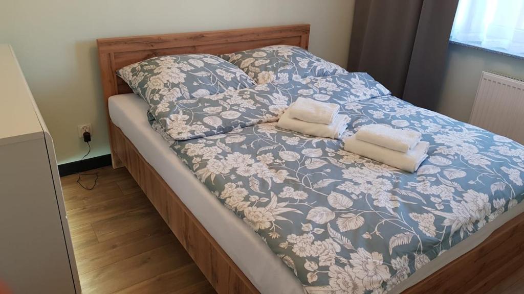 比亚韦斯托克Apartamenty Homely - Nowowarszawska 130的一张带蓝色和白色毯子及两个枕头的床