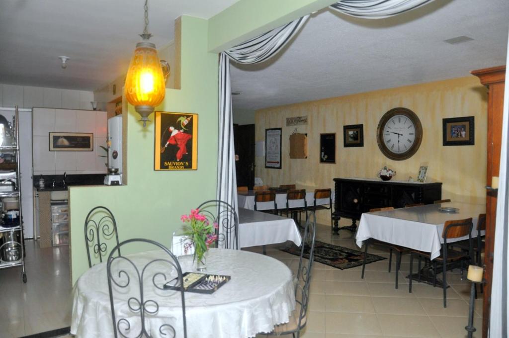 里约达欧特拉斯ANGEL'S SEA Pousada的餐厅设有桌椅和墙上的时钟