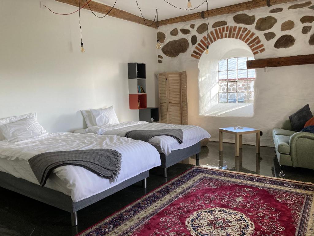 FlyingeRoslövs gård vackert boende i en naturskön miljö.的卧室配有两张床、一张沙发和一个地毯。