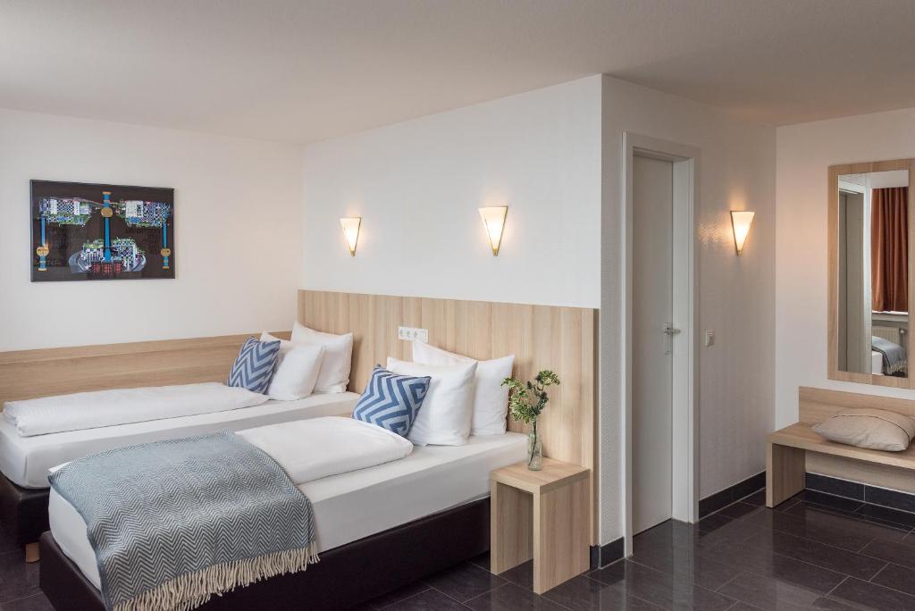 明斯特孔蒂中央铁路站霍夫酒店的酒店客房带两张带蓝白色枕头的床