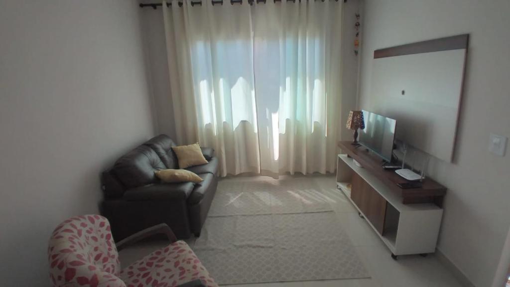 伊瓜苏Casa aconchegante com piscina e bem localizada的带沙发和电视的客厅