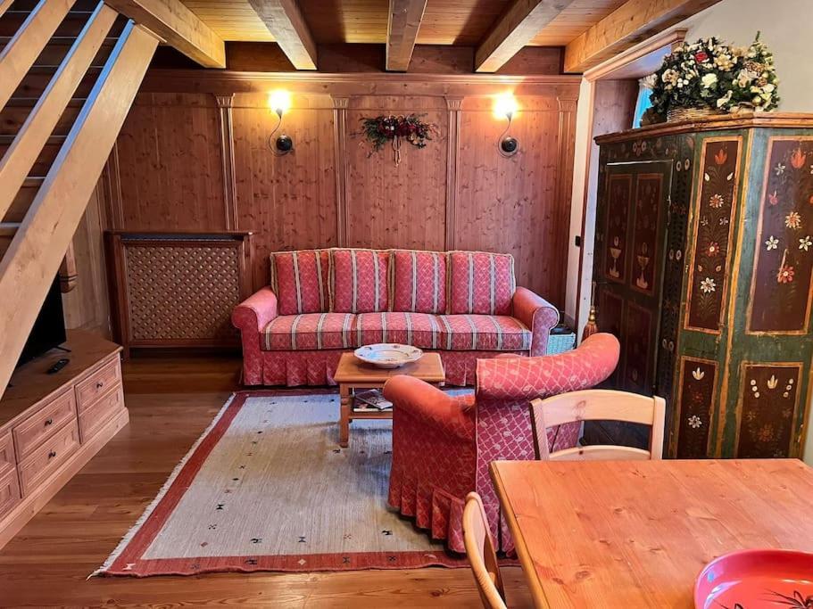 圣维托-迪卡多雷Mansarda su due livelli nel cuore delle Dolomiti的客厅配有沙发和桌子