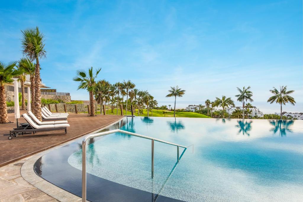 吉亚德伊索拉Los Jardines de Abama Suites的一座棕榈树环绕的游泳池