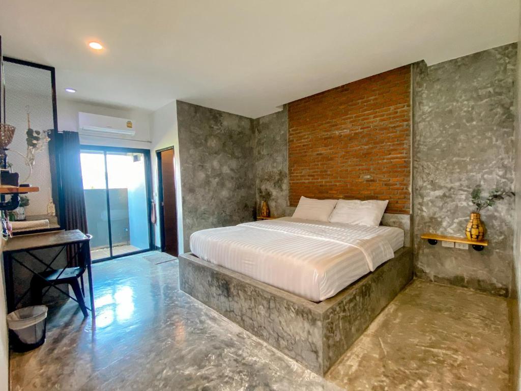 佛丕平查诺克度假村的一间卧室设有一张床和砖墙