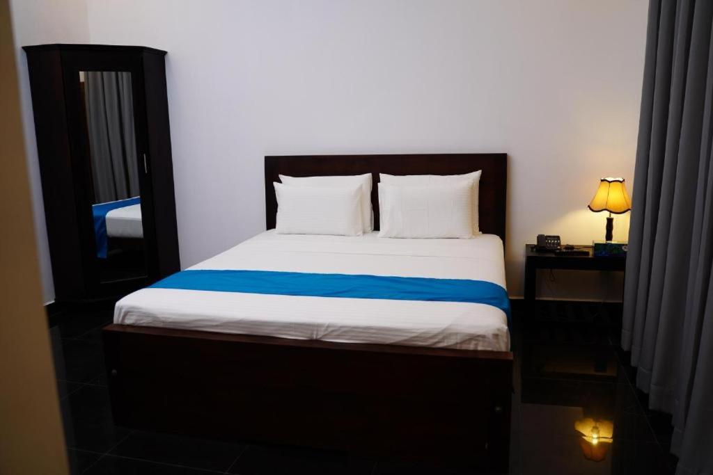Point PedroVillage Hotel Northern Point的一间卧室配有一张带蓝色毯子的床