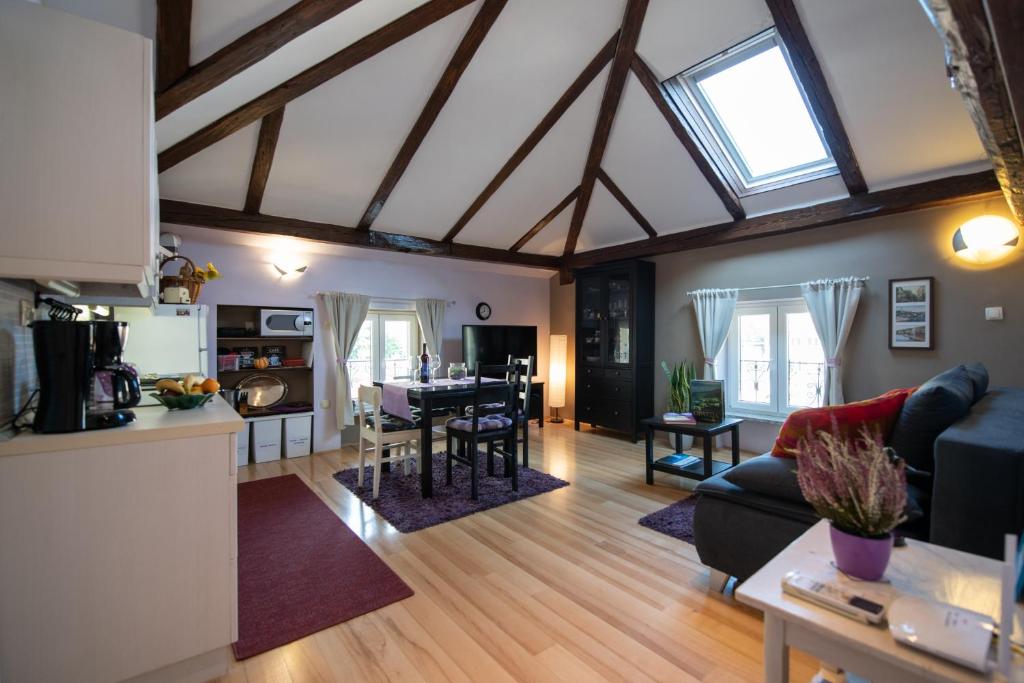 奥帕提亚Apartment Vanja的厨房以及带横梁天花板的客厅。