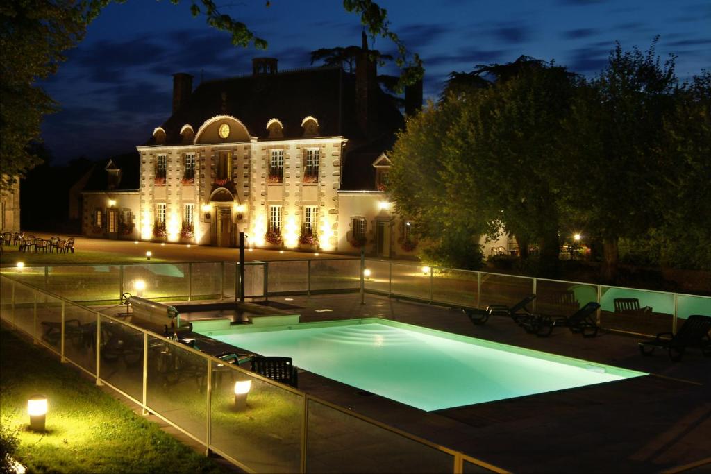 穆莱玛乔莲之家酒店的一座游泳池,在晚上在建筑物前