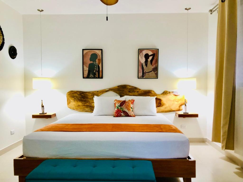 别霍港Olinca Boutique Hotel的一间卧室配有一张大床和木制床头板