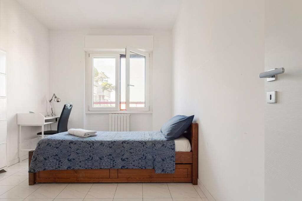 罗扎诺Attico incantevole - Forum Assago & Humanitas的一间卧室配有一张床、一张书桌和一个窗户。