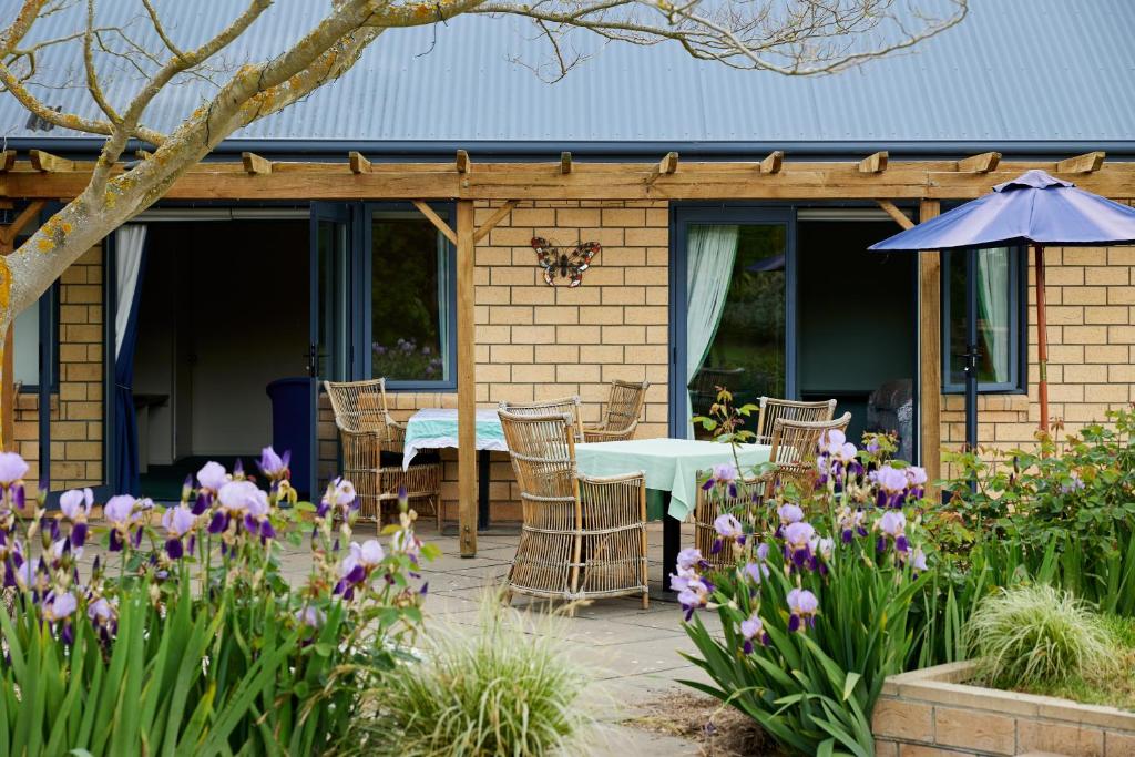 凯库拉Awatea Country Bed & Breakfast的庭院配有桌椅和鲜花