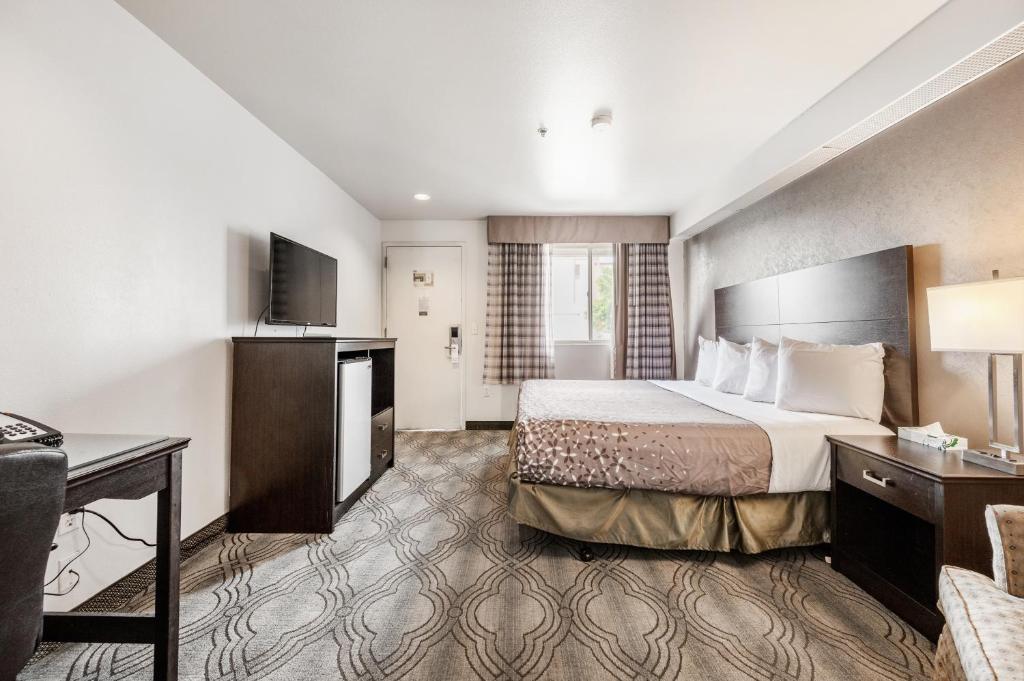 盐湖城市溪汽车旅馆的配有一张床和一张书桌的酒店客房