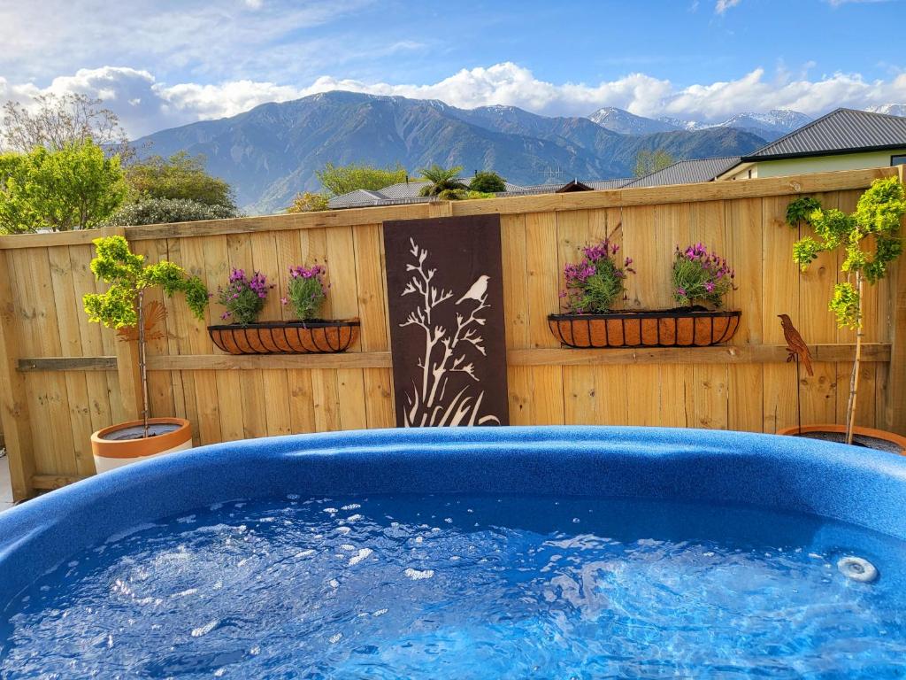 凯库拉Te Mahuru Retreat的院子里的热水浴池,带围栏和鲜花