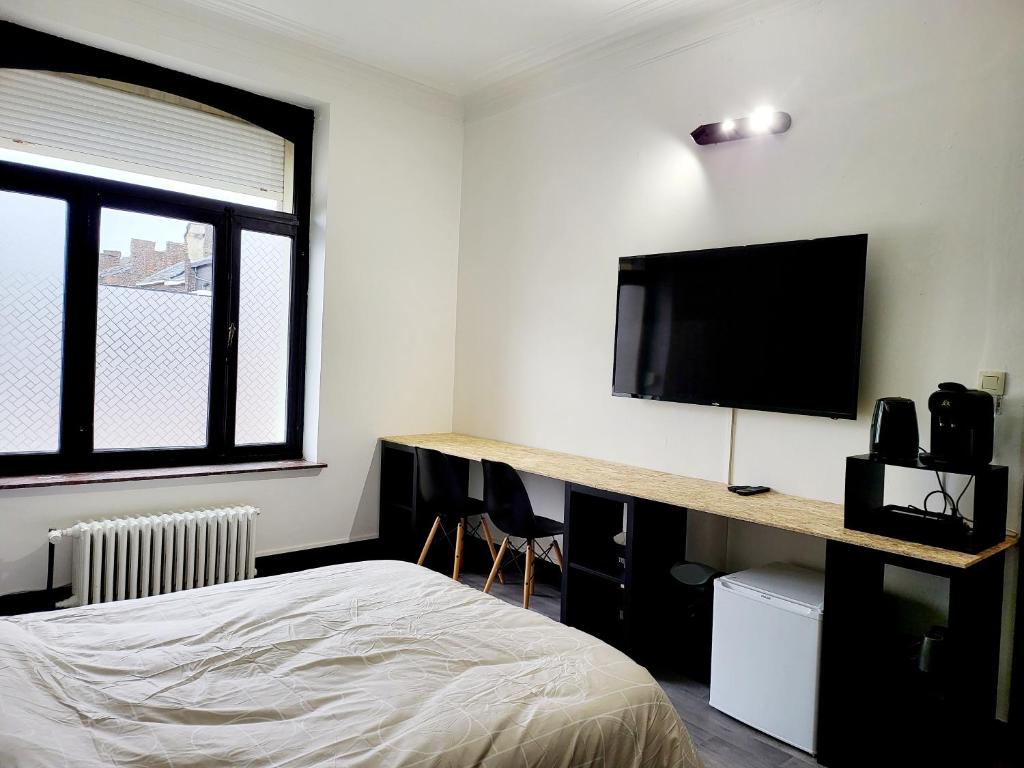 沙勒罗瓦Private industrial room in center of Charleroi的一间卧室配有一张床和一台平面电视
