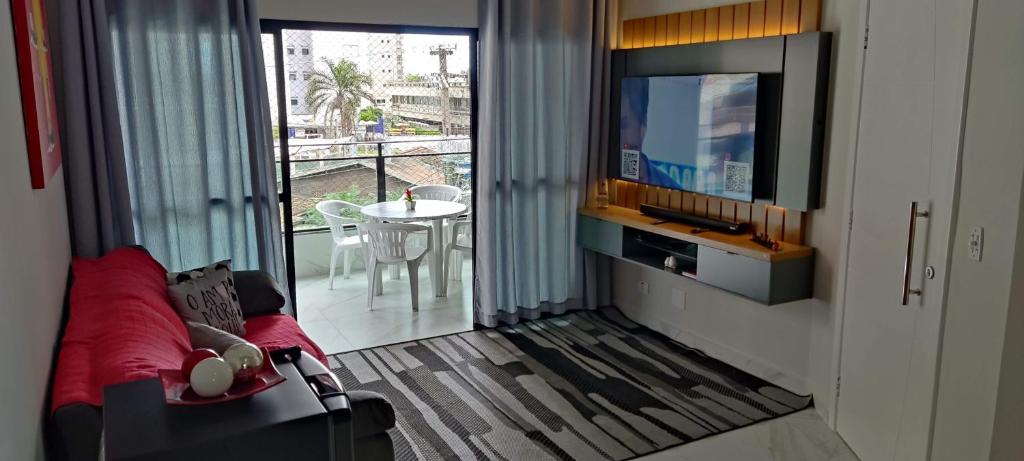 瓜鲁雅Apartamento Guarujá Astúrias的带沙发和平面电视的客厅