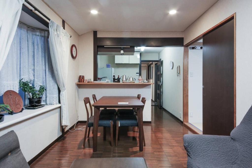 东京Homestay Intimo Amigo的厨房以及带桌椅的用餐室。