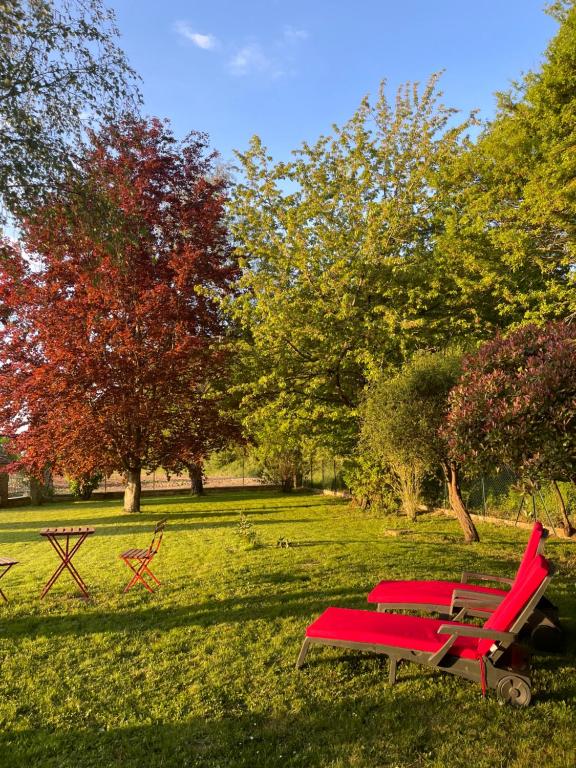 Chailly-en-BièreChambre d’hôte的公园里两张红色的椅子和一张野餐桌