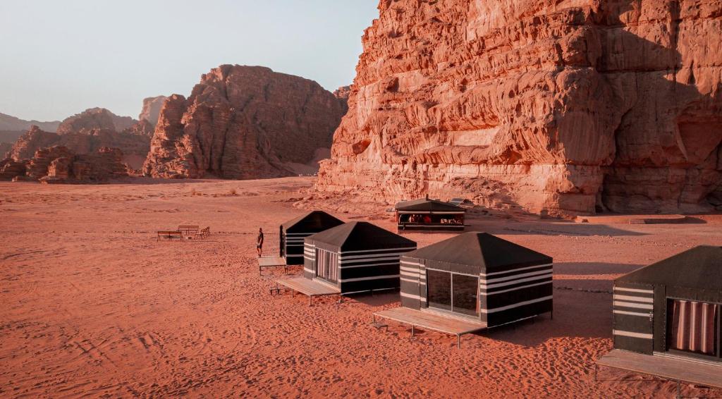瓦迪拉姆Desert Bird Camp的悬崖附近的沙漠中一群小屋