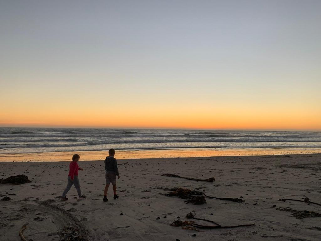 StrandfonteinStrandfontein holiday house的两人在日落时分在海滩上散步