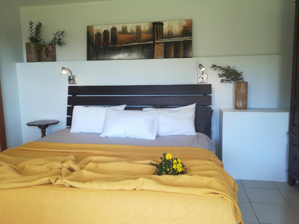 戈登湾Crossroads Guestrooms的一张黄色毯子和鲜花的床