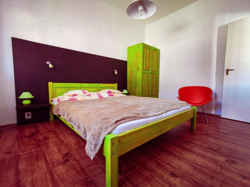 鲍洛通费尼韦什Apartment for 5 ppl at Lake Balaton的一间卧室配有绿色的床和红色椅子