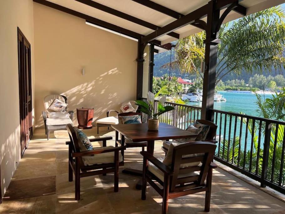 伊甸岛Waterfront Maison by Simply-Seychelles的阳台的用餐室配有桌椅