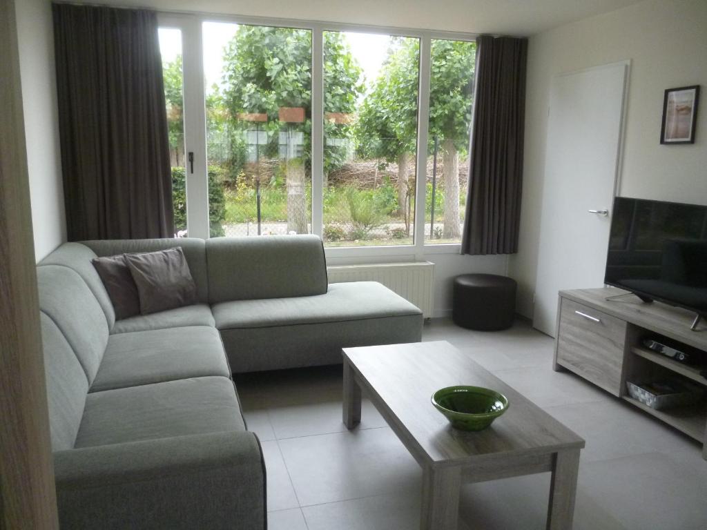 米德尔克尔克Vakantiewoning De Zandkorrel的带沙发、电视和桌子的客厅