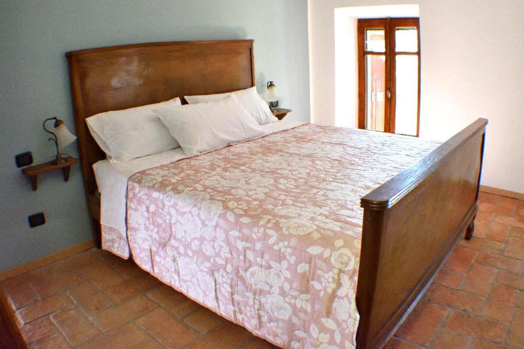 Ozzano Monferratob&b CASCINA SORTINA Country House的一间卧室配有一张大床和木制床头板
