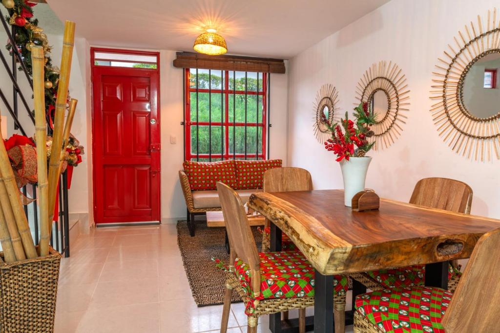 萨兰托APARTAMENTO MI REFUGIO的一间带木桌和红色门的用餐室