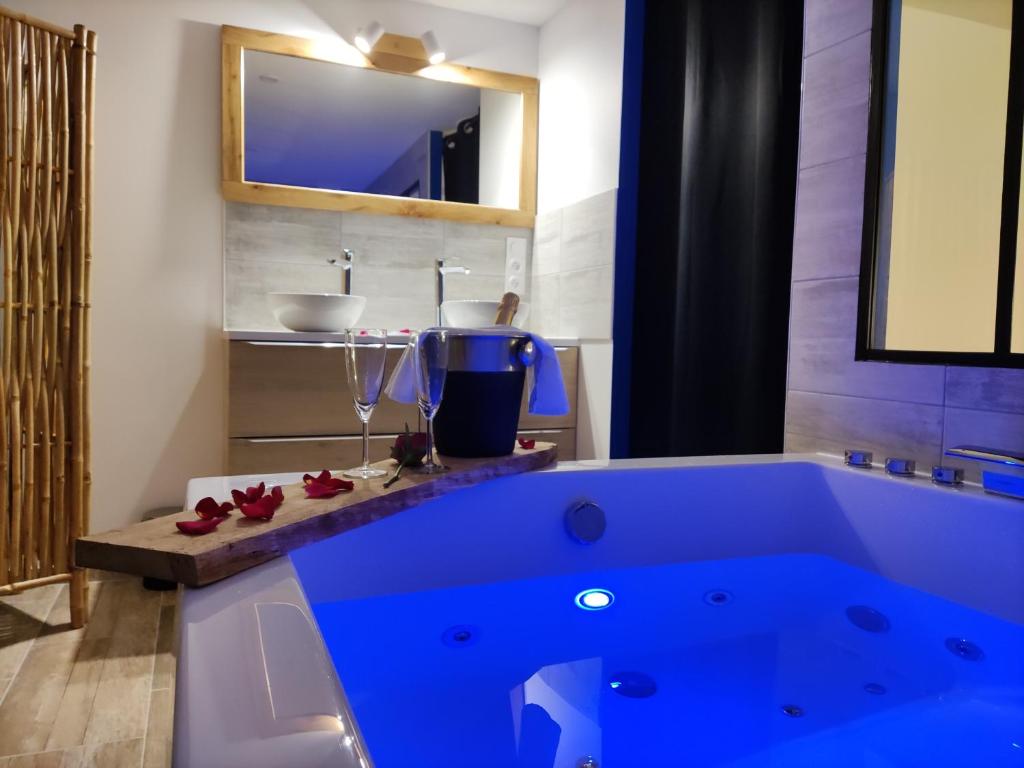 维希Maison de ville, SPA Balnéo, 2 suites parentales的一个带水槽的浴室内的大蓝色浴缸