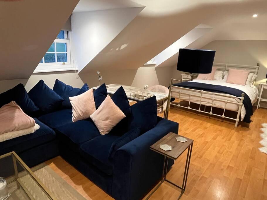奥尔德马斯顿The Pheasantry - guest house in beautiful rural location的客厅配有蓝色的沙发和床。