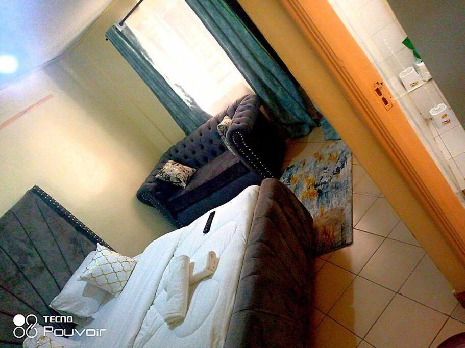 内罗毕Attic place South B.的卧室配有一张床和一张沙发,享有风景。