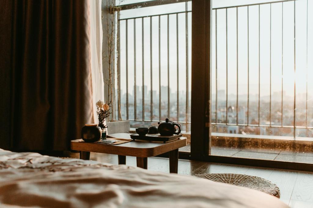 河内Apastar Luxury - Vinhomes Smart City的卧室配有一张床,窗户前设有一张桌子