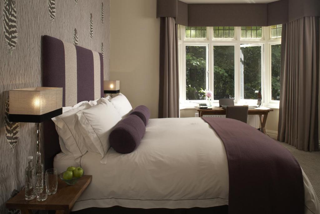 伯恩茅斯格林别墅酒店的卧室配有一张带紫色枕头的大型白色床。