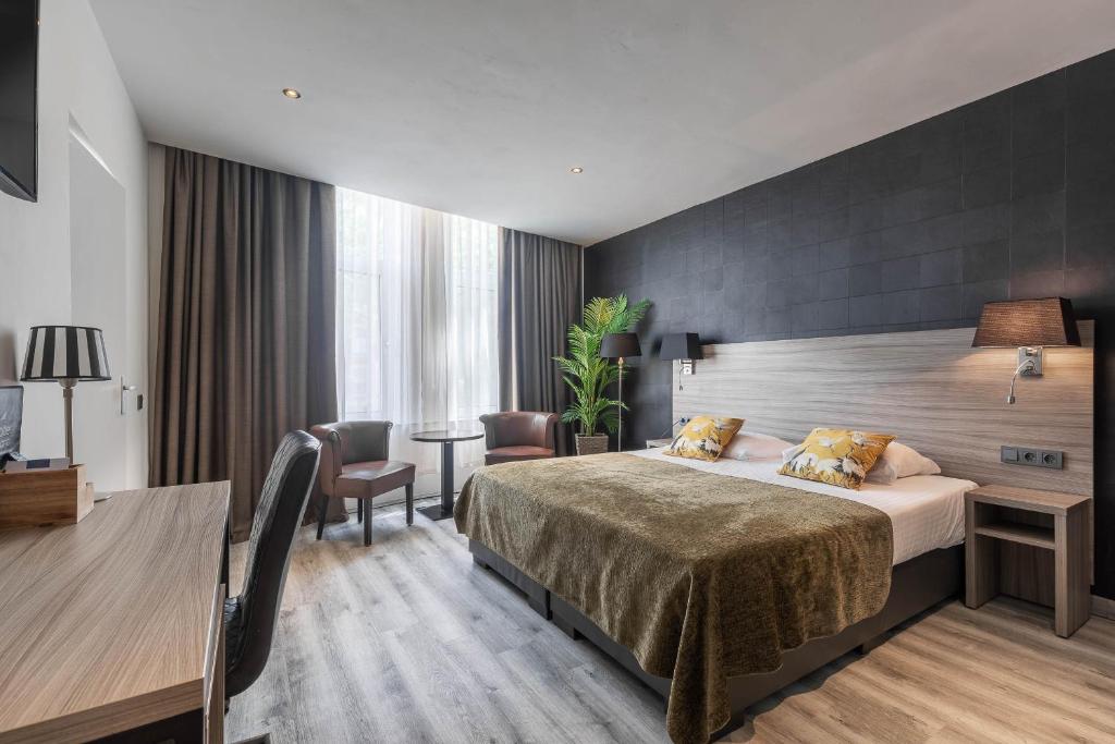 鹿特丹米兰诺酒店的配有一张床和一张书桌的酒店客房