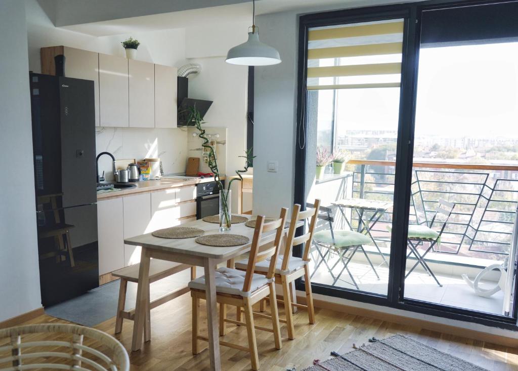 斯科普里Sunlight Apartment的一个带桌椅的厨房和一个阳台