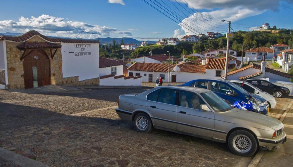 瓜塔维塔HOSPEDAJE DE GUATAVITA的停在一个城镇旁边的停车场的汽车