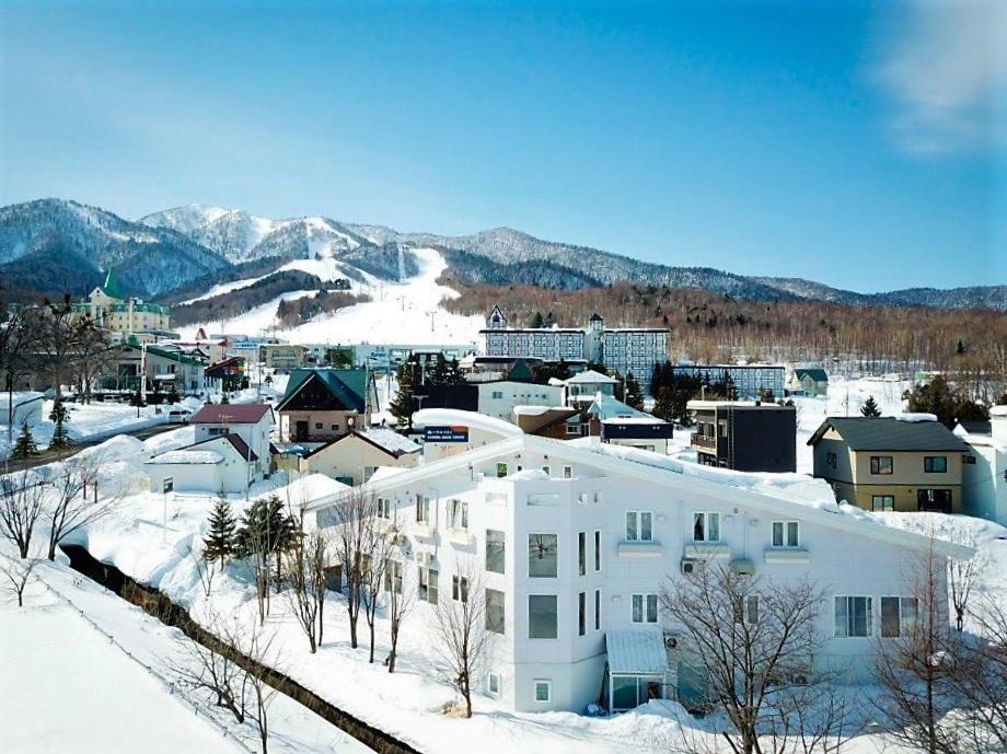 富良野弗拉诺住宿加早餐旅馆的雪中白色的建筑,与城市