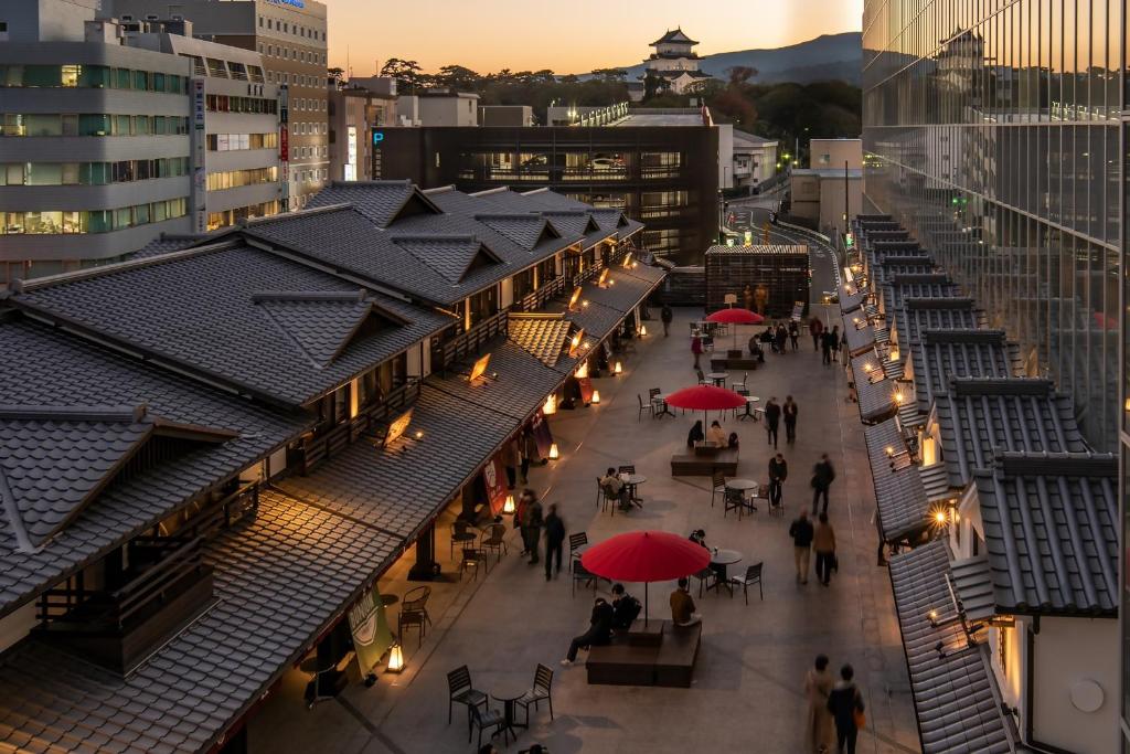 小田原市Tenseien Odawara Station Annex的一群人用遮阳伞沿着街道走着