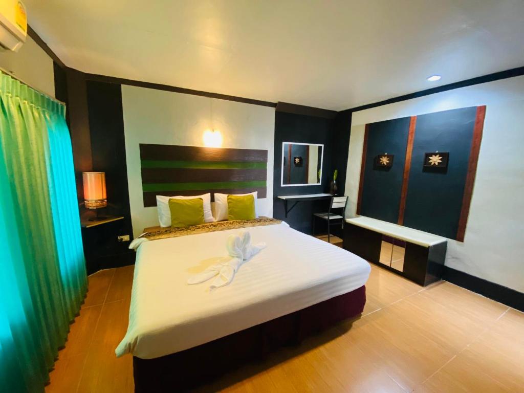 攀牙帕科尔精品度假酒店的一间卧室,配有一张白色花卉床