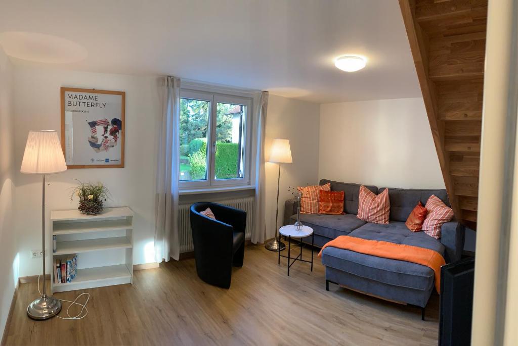 布雷根茨Chalet zum See的客厅设有蓝色的沙发和窗户。